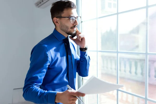Handsome young businessman using his mobile phone in the office. — Stock Photo, Image