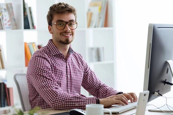 Onun laptop kullanma office yakışıklı genç işadamı.