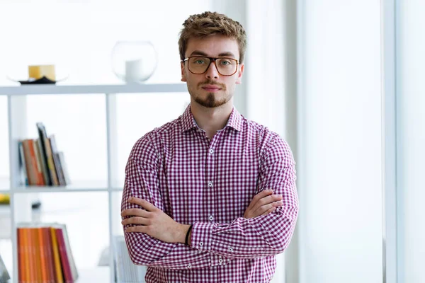 Handsome young businessman looking at camera in the office. — Stock Photo, Image