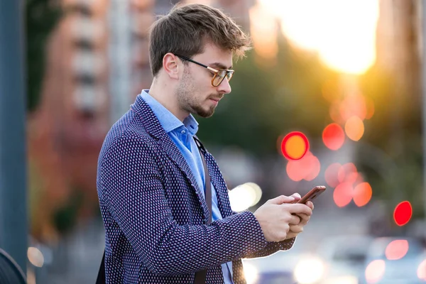 Przystojny, młody biznesmen, za pomocą swojego telefonu komórkowego na ulicy. — Zdjęcie stockowe
