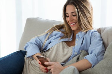 Güzel genç kadın cep telefonu evde kullanma.