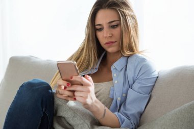 Güzel genç kadın cep telefonu evde kullanma.