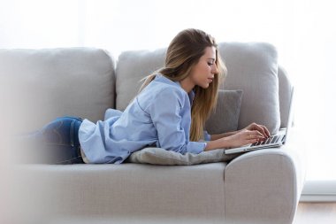 Evdeki bilgisayarını kullanan güzel bir genç kadın..