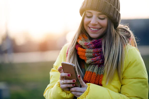 Parkta cep telefonu kullanan güzel genç kadın.