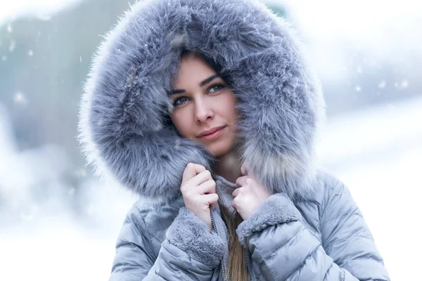 Schöne junge Frau schaut seitwärts in den Wald an einem Wintertag mit Schnee. — Stockfoto