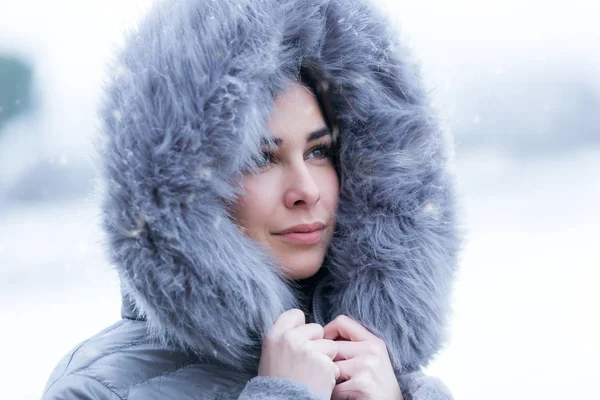 Hermosa mujer joven mirando de lado en el bosque en un día de invierno con nieve . — Foto de Stock