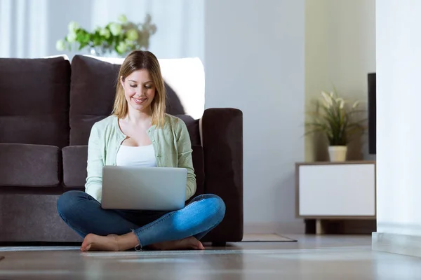 Schöne junge Frau benutzt ihren Laptop zu Hause. — Stockfoto