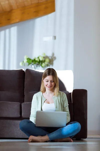 Schöne junge Frau benutzt ihren Laptop zu Hause. — Stockfoto