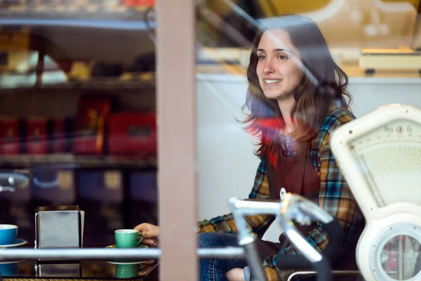 Hermosa joven vendedora relajarse y beber café en la tienda orgánica . —  Fotos de Stock