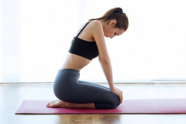 Sportif genç kadının hypopressive abs kapalı yapması.