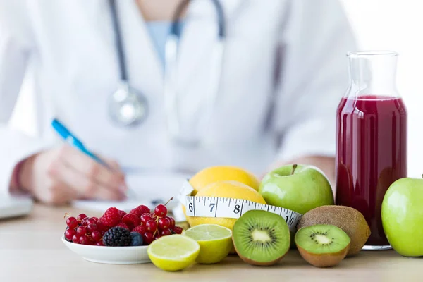 Obst wie Äpfel, Kiwis, Zitronen und Beeren auf dem Tisch des Ernährungswissenschaftlers. — Stockfoto