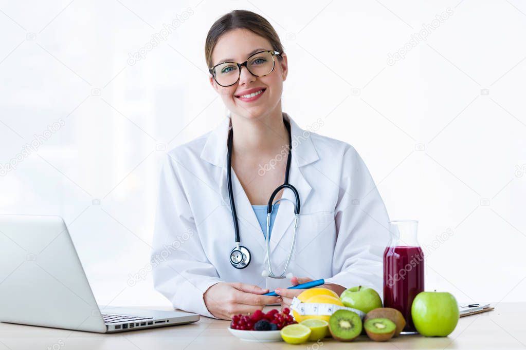 Young smiling female nutritionist looking at camera in the consultation.