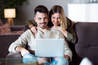 Güzel genç çift istimal onların laptop vasıl ev gülümseyen.