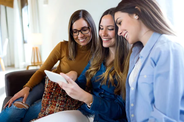 Drei glückliche schöne Frauen mit Smartphone zu Hause. — Stockfoto