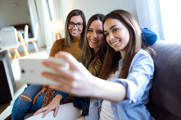 Drei glückliche schöne Frauen machen ein Selfie und genießen die gemeinsame Zeit zu Hause. — Stockfoto