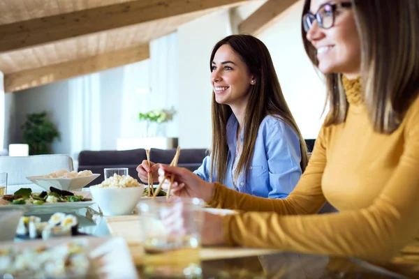 İki güzel genç kadın evde Japon yemek yeme.