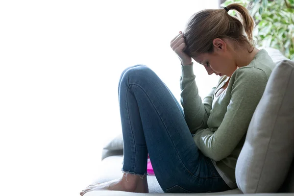 Unglücklich einsame depressive junge Frau, die zu Hause auf dem Sofa sitzt. Depressionskonzept. — Stockfoto