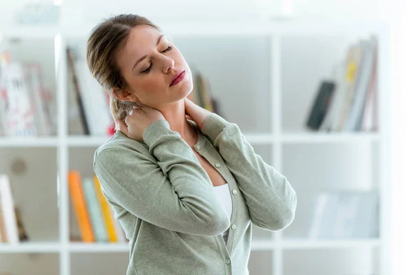 Tired young woman with neck pain at home. — Stock Photo, Image