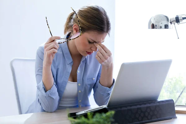 Trött ung kvinna med huvudvärk med hennes laptop hemma. — Stockfoto