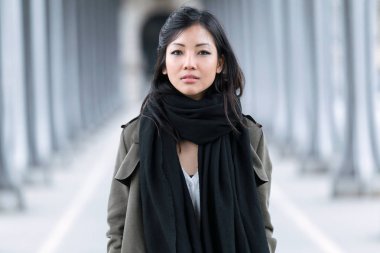 Poz ve kamera sokakta bakarak moda Asyalı genç kadın.