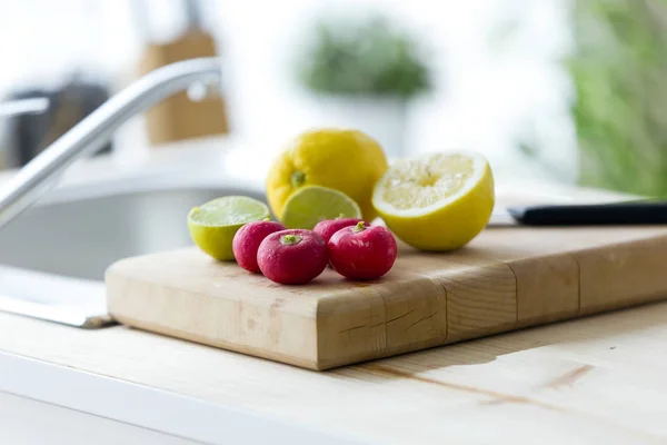 Lemon, lime and tomatoes on wood board in the kitchen at home. — Stock Photo, Image