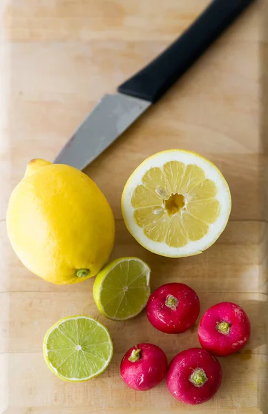 Lemon, lime and tomatoes on wood board in the kitchen at home. — Stock Photo, Image