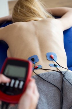 Genç physioterapist Fizyo Oda bir hastada fizik tedavi elektro stimülasyon uygulamak.
