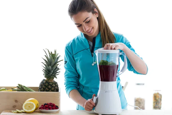 Belle jeune femme préparant du jus de désintoxication dans le mélangeur à la maison . — Photo