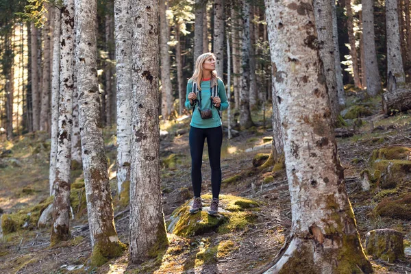 Bonita joven viajera con mochila mirando a un lado en el bosque natural . — Foto de Stock