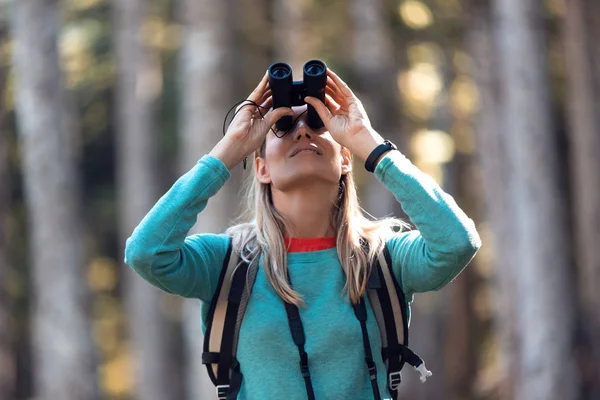 O femeie tânără care caută păsări prin telescop binoclu în pădure . — Fotografie, imagine de stoc