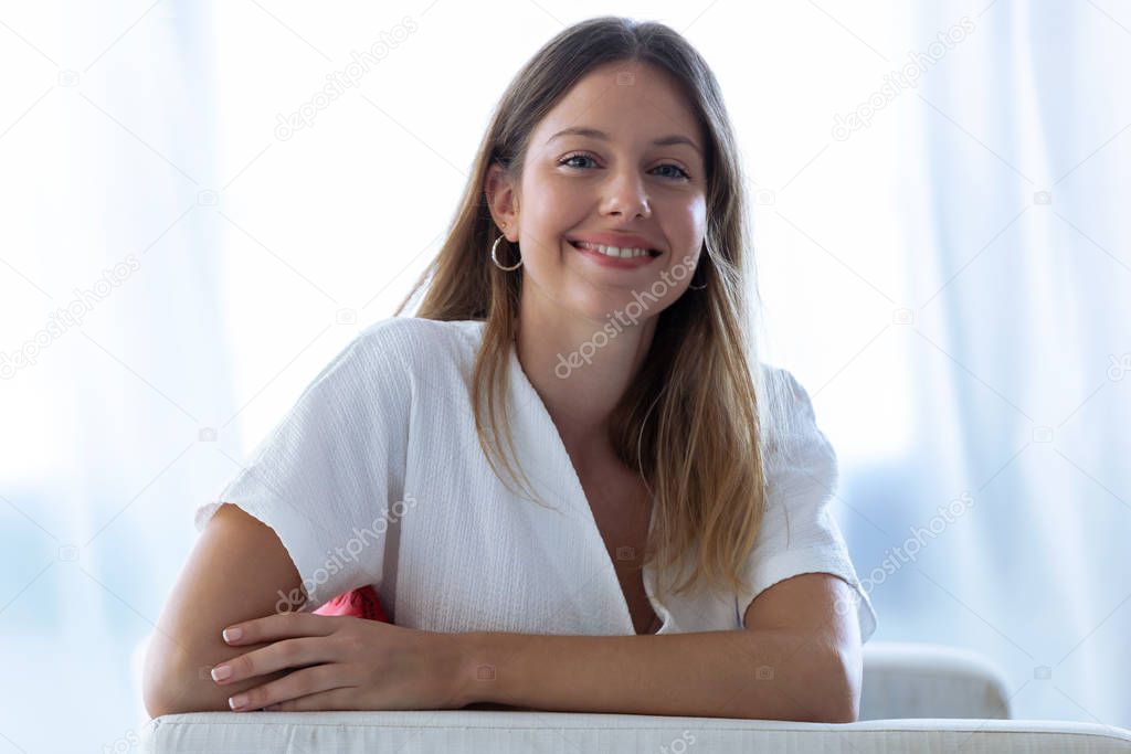 Happy young woman with perfect smile looking at camera at home.