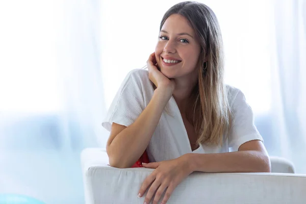 Mujer joven feliz con una sonrisa perfecta mirando a la cámara en casa . Imagen De Stock