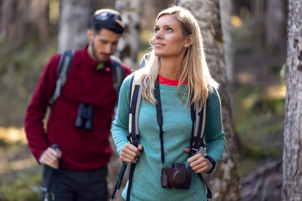 Dois caminhantes de viagem com mochila andando enquanto olha a paisagem na floresta . — Fotografia de Stock