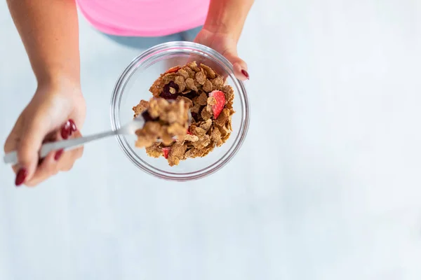 Woman's hands holding bowl with cereals and strawberries. — Stock Photo, Image