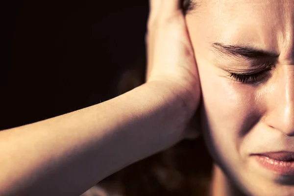 Mladá žena zblízka s bolestí hlavy na černém pozadí. Myšlenka duševní choroby. — Stock fotografie