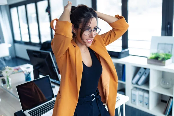 Mujer joven de negocios recibiendo una cola de caballo para trabajar en la oficina . — Foto de Stock