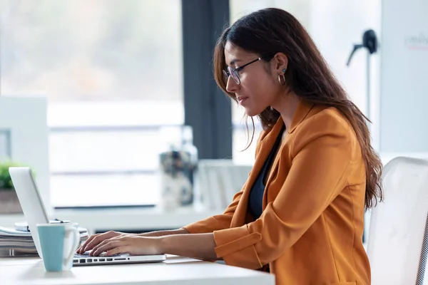 Mujer joven de negocios que trabaja con el ordenador portátil en la oficina . — Foto de Stock