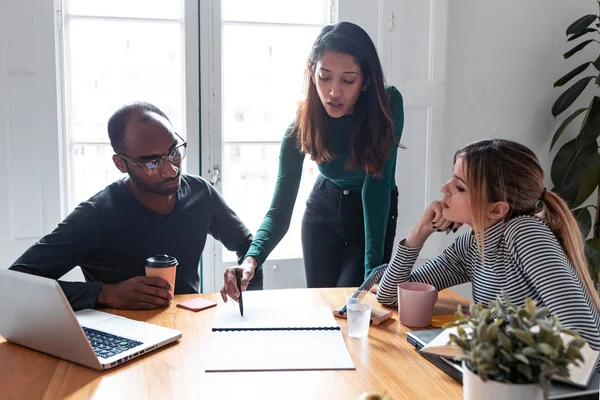 Bella giovane imprenditrice donna spiegando un progetto ai suoi colleghi sul posto di lavoro . — Foto Stock