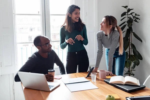 Pretty young entrepreneur woman explaining a project to his colleagues on coworking place. — Stock Photo, Image