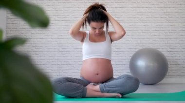 Doğum öncesi sınıfta pilates egzersizleri yaptıktan sonra esneme güzel genç hamile kadın.