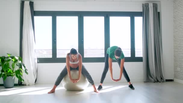 Vacker gravid kvinna med sin sjukgymnast gör Pilates övningar förbereder för förlossning. — Stockvideo