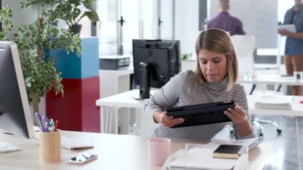 Две деловые девушки, работающие вместе с цифровым планшетом в современном стартап-офисе . — стоковое видео