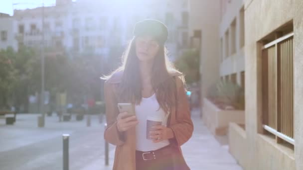 Vídeo Una Mujer Joven Bonita Usando Teléfono Móvil Mientras Sostiene — Vídeos de Stock