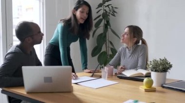 Video of pretty young entrepreneur woman explaining a project to his colleagues on coworking place.