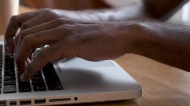 Close-up of a man's hands using the computer keyboard in the office.