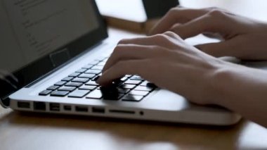 Close-up of a woman's hands using the computer keyboard in the office.