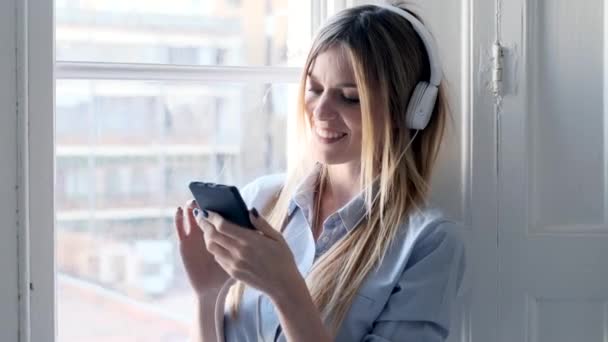 Video Pretty Young Woman Listening Music Headphones Using Smartphone Home — ストック動画