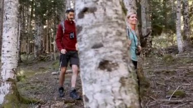 Video of two travel hikers with backpack walking while looking the landscape in the forest.