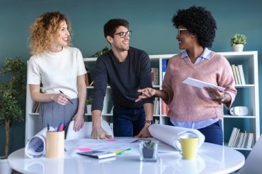 Gelişigüzel genç girişimcilerin ofiste birlikte çalışıp yeni işlerinden bahsetmeleri..
