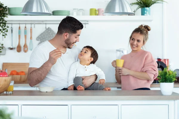 Tiro Belo Jovem Pai Alimentando Seu Filho Enquanto Mãe Olhando — Fotografia de Stock